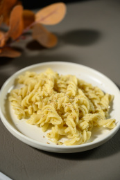 桌面上的盘子里的美味可口的青酱螺丝粉