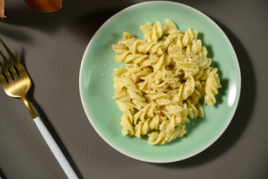 桌面上的盘子里的美味可口的青酱螺丝粉