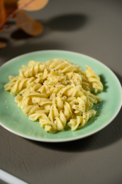 桌面上的盘子里的美味可口的青酱螺丝粉