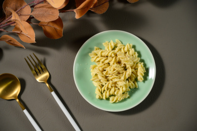 桌面上的盘子里的美味可口的青酱螺丝粉