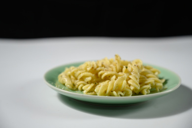 桌面上的盘子里的美味可口的青酱螺丝粉