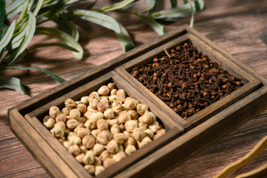 桌面上的盘子里的香气四溢的丁香和白豆蔻