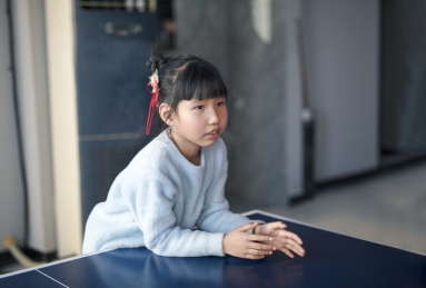 乒乓球桌上趴着的小女孩
