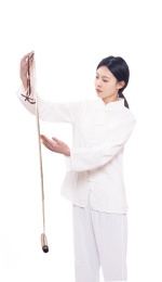 穿着白色练功夫唐装的年轻女性拿着画轴