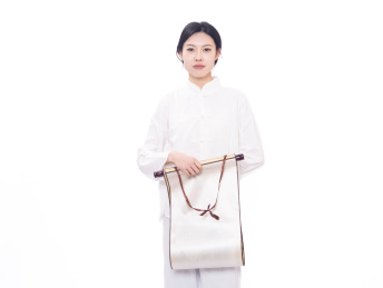 穿着白色练功夫唐装的年轻女性拿着画轴