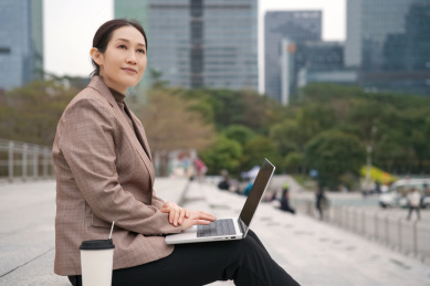 职业女性使用笔记本电脑和手机进行多任务处