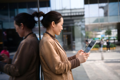城市景观中的职业女性浏览平板电脑 