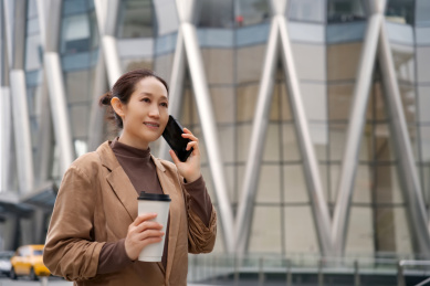 微笑的职业女性多任务处理电话和咖啡