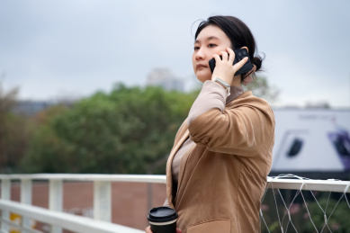 年轻的职业女性在户外接听电话