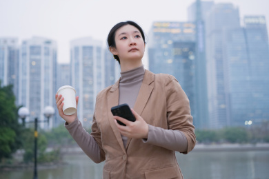 女人在城市河滨步道上喝咖啡