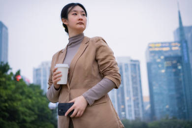 女人在城市河滨步道上喝咖啡