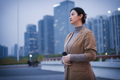 年轻女子在城市街道上使用智能手机