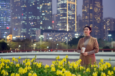 夜晚在城市里喝咖啡散步的职业女性