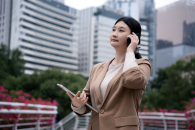 在户外使用笔记本电脑打电话的职业女性