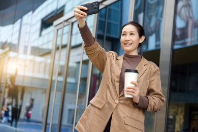 自信的女商人与智能手机在城市