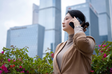 摩天大楼旁的职业女性打电话