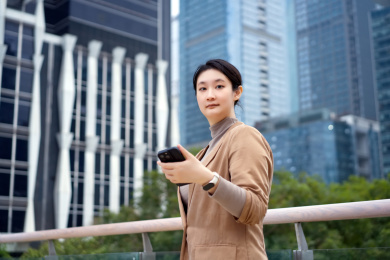自信的职业女性与咖啡和电话的多任务处理