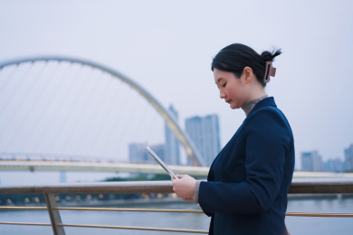 城市景观中的职业女性浏览平板电脑 