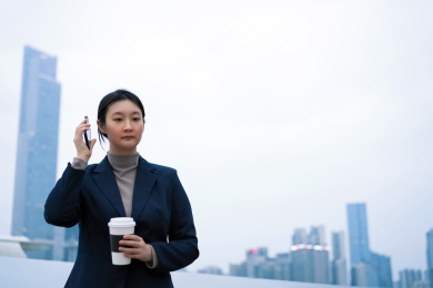 自信的职业女性在办公楼外打电话