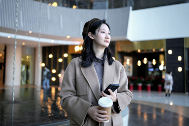 现代城市景观中手持智能手机的职业女性