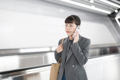 地铁站走路边打电话去上班的女人