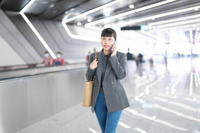 地铁站走路边打电话去上班的女人