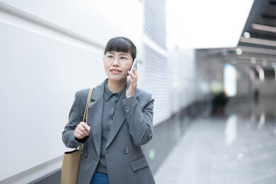地铁站走路边打电话去上班的女人