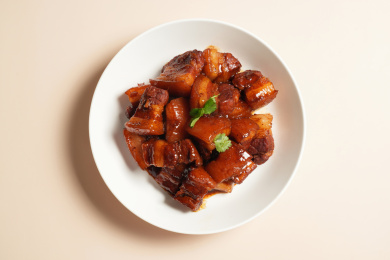 一盘美味可口的红烧肉放在白色盘子中