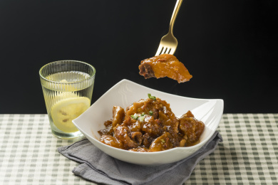 一盘红烧牛窝骨摆放在桌面上特写