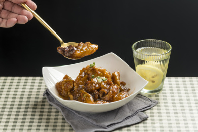 一盘红烧牛窝骨摆放在桌面上特写