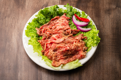 木纹桌上有一盘生制牛胸口肉片