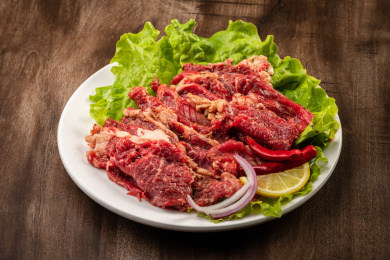 木纹桌上有一盘腌制牛肉片