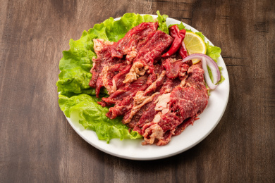 木纹桌上有一盘腌制牛肉片