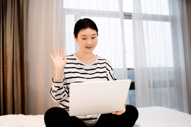 年轻女子在笔记本电脑上的视频通话中问候