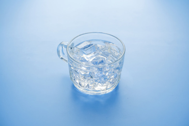 蓝色背景的一杯冰块冰水