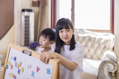 客厅里正在做游戏的姐弟俩