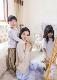 客厅里年轻的母亲陪着姐弟俩做游戏