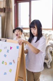 客厅里正在做游戏的姐弟俩