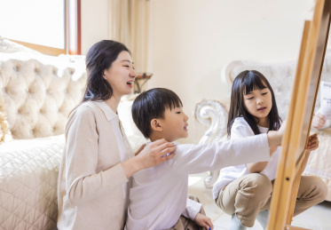 客厅里年轻的母亲陪着姐弟俩做游戏