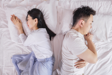 卧室里躺在床上吵架的年轻情侣