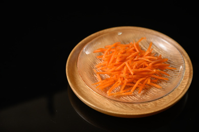 桌面上的盘子里的美味可口的新鲜胡萝卜丝