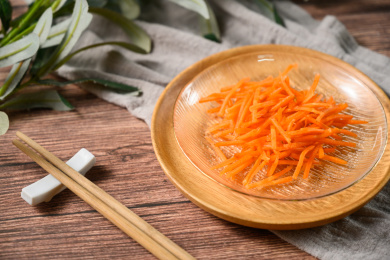 桌面上的盘子里的美味可口的新鲜胡萝卜丝