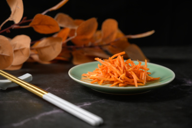 桌面上的盘子里的美味可口的新鲜胡萝卜丝