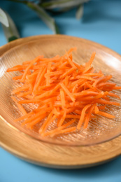 桌面上的盘子里的美味可口的新鲜胡萝卜丝