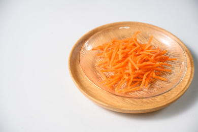 桌面上的盘子里的美味可口的新鲜胡萝卜丝