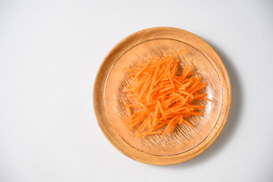 桌面上的盘子里的美味可口的新鲜胡萝卜丝
