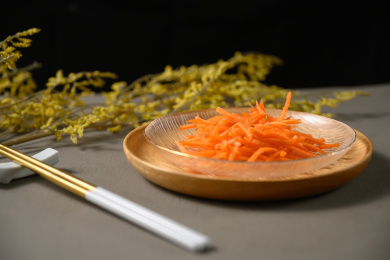 桌面上的盘子里的美味可口的新鲜胡萝卜丝