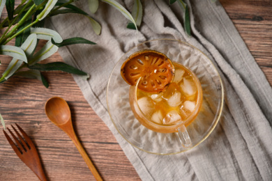 桌面上的杯子里的甘甜可口的冰木橘茶
