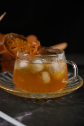 桌面上的杯子里的甘甜可口的冰木橘茶