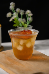 桌面上的杯子里的甘甜可口的冰木橘茶